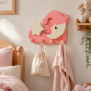 Porte-manteau enfant lune et étoile rose en bois avec quatre patères dans une chambre d’enfant