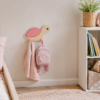 Porte-manteau enfant en bois en forme de petite tortue rose, installé dans une chambre d’enfant et équipé de deux crochets.